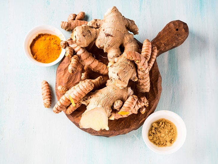 a bowl with turmeric roots and powder