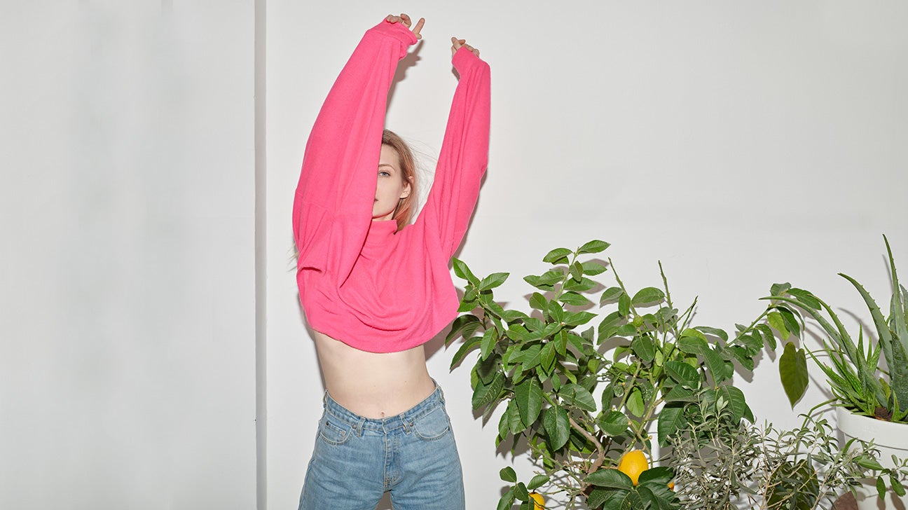 Woman standing next to indoor lemon plant