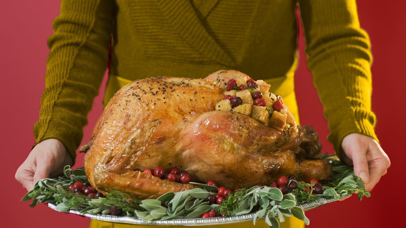 hands holding a thanksgiving turkey on a platter