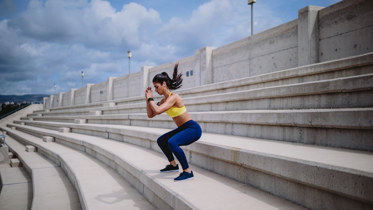 young woman doing squats on risers