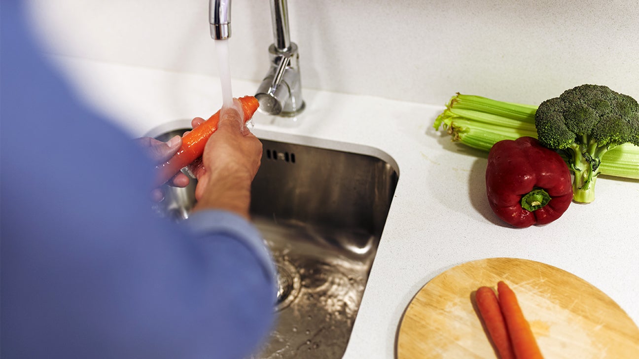 closeup on hands washing vegetables