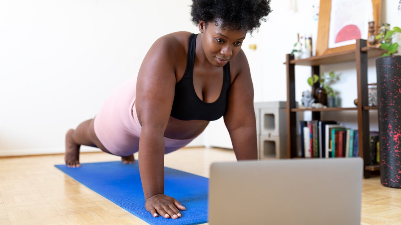 woman doing plank in front of computer screen