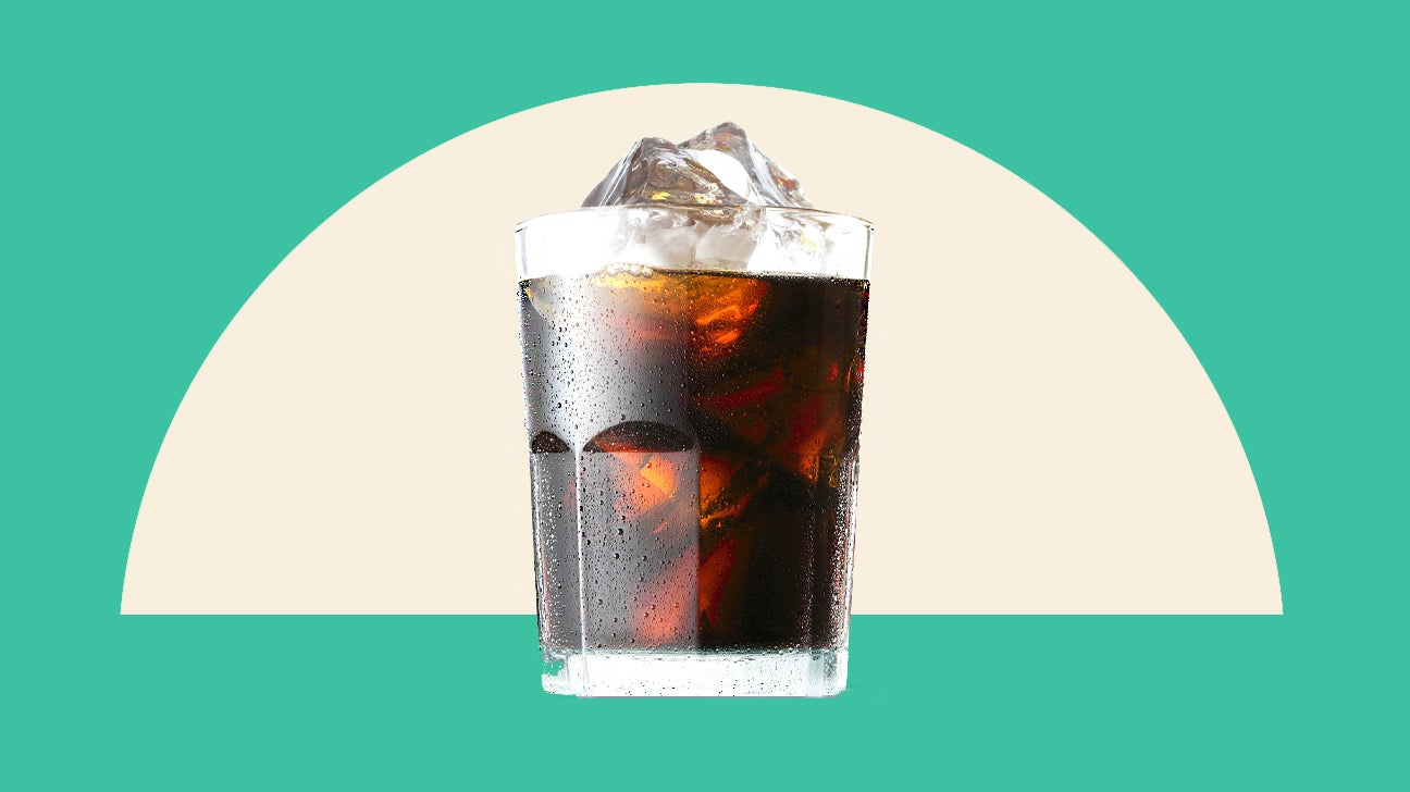 Glass of iced coffee on a background of beige and green