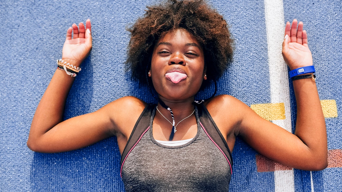 person sticking their tongue out lying on blue background