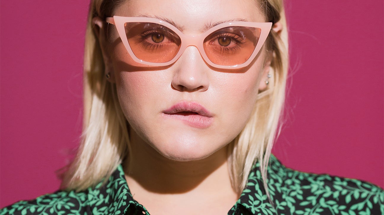 person with pink glasses biting lip