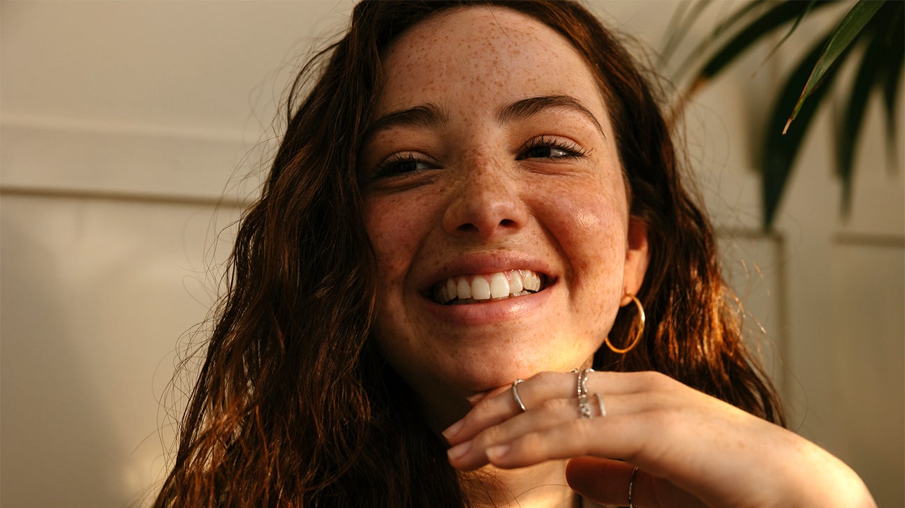 female with freckles smiling